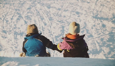 两个人白天坐在雪地上